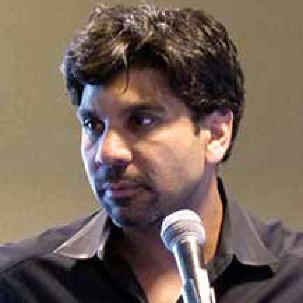 Jishnu Das giving a speech with a microphone in front of him.