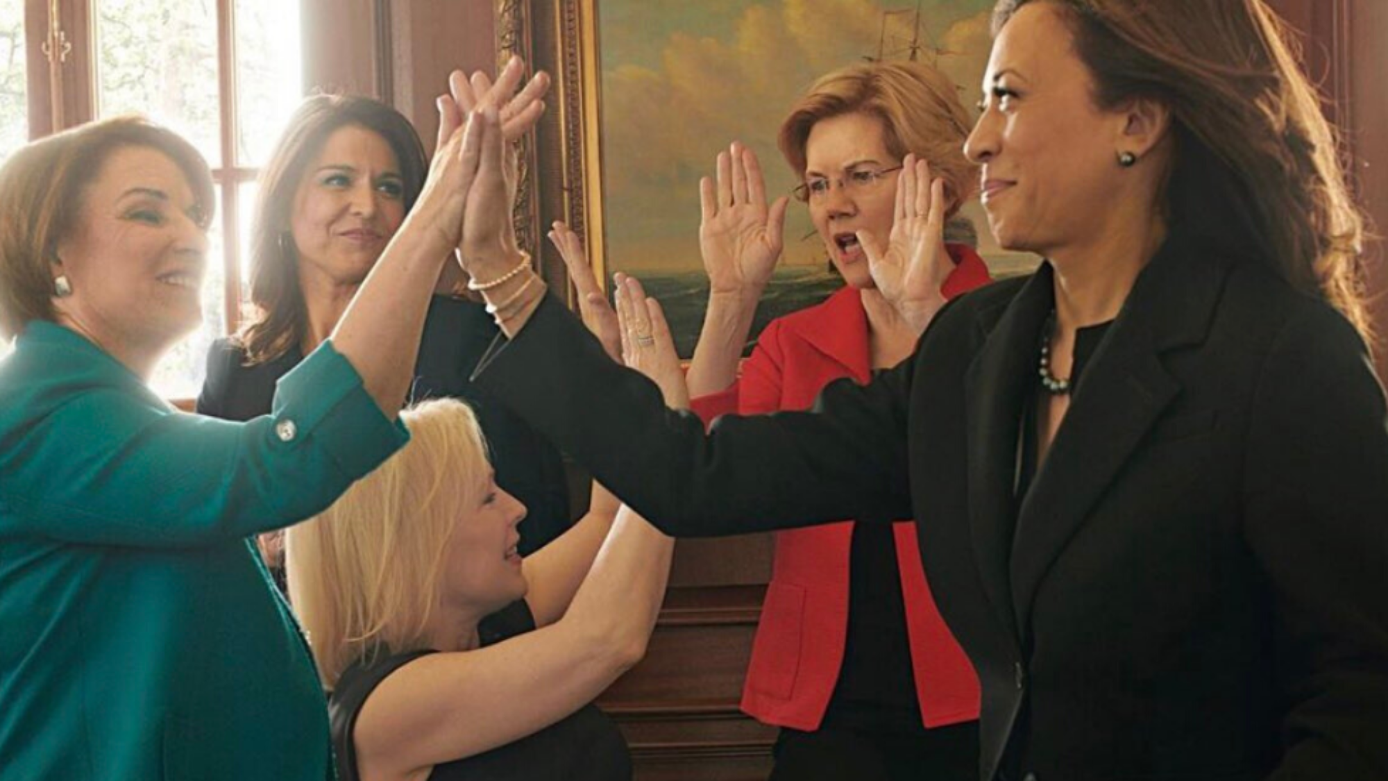 Female political leaders giving each other high-fives
