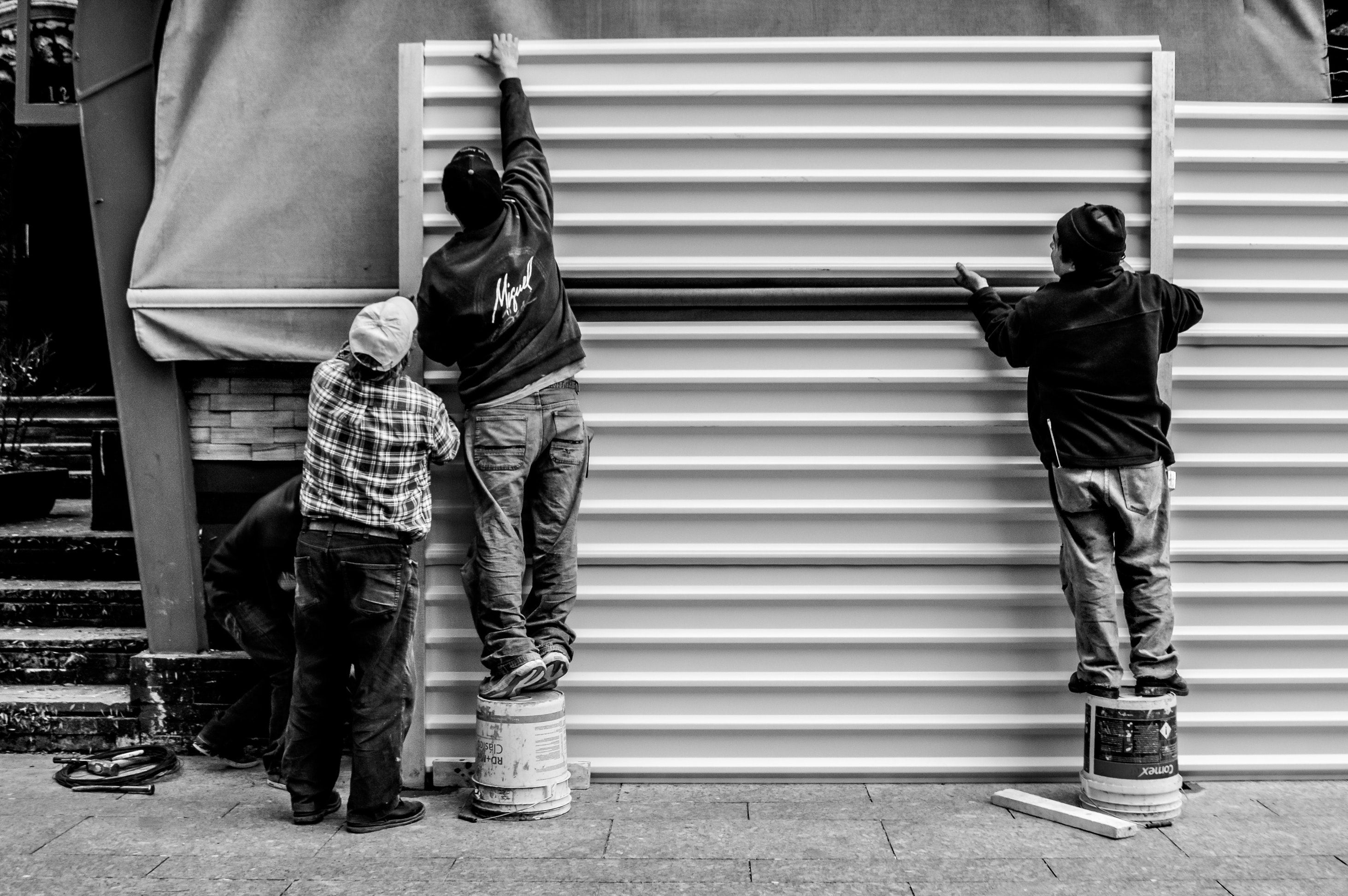 Photo of workers arranging a metal wall