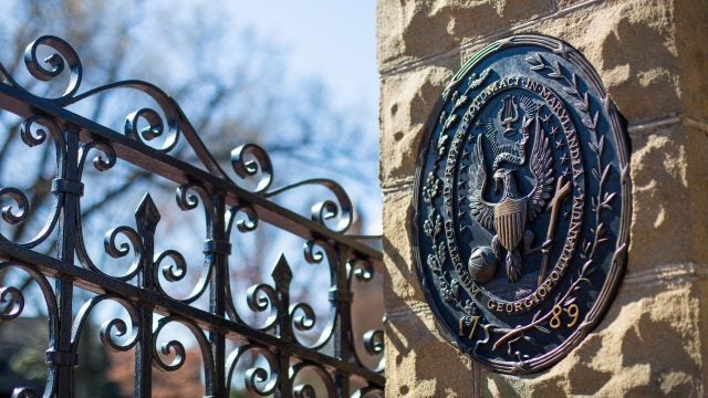 Georgetown front gates with university seal in the foreground