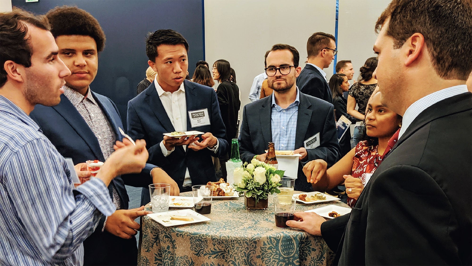 McCourt Students attending an event - standing at a table in a discussion