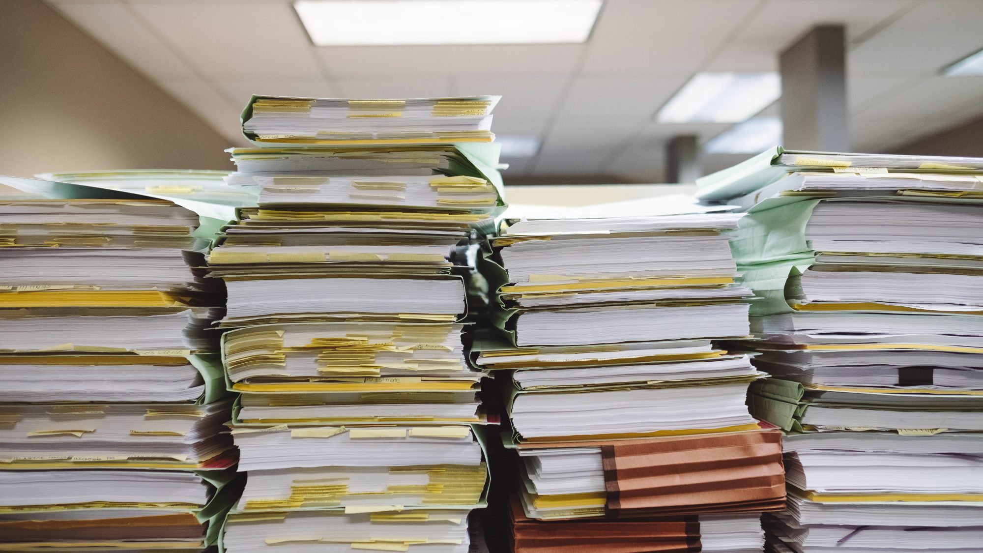 Four stacks of paper on a desk
