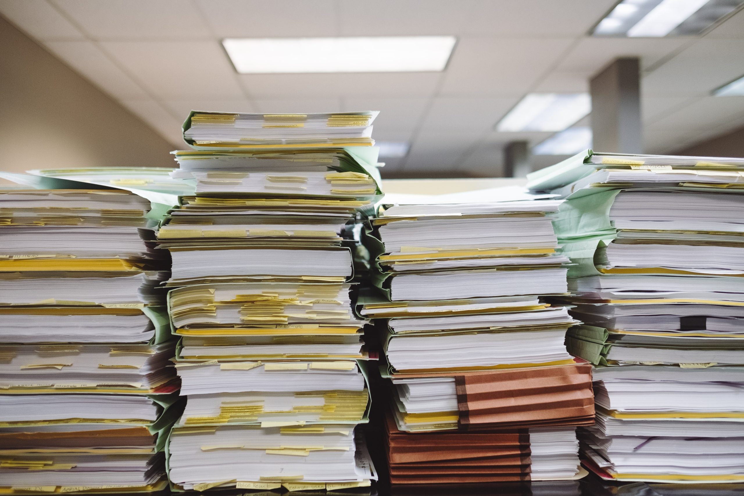 Four stacks of paper on a desk