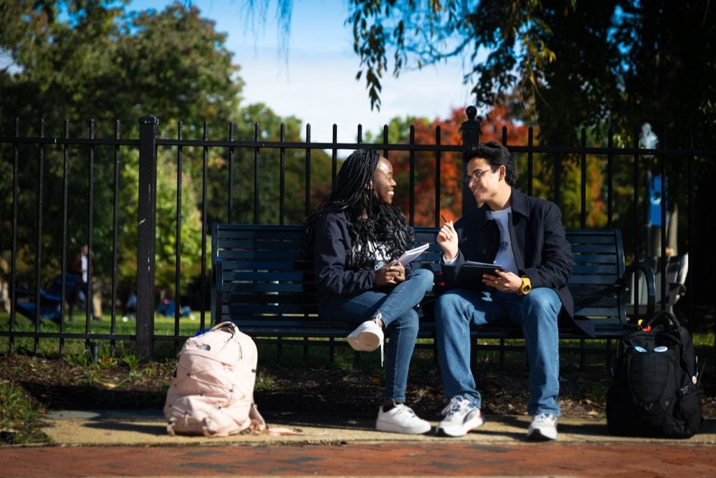 Students talking on a bench outside