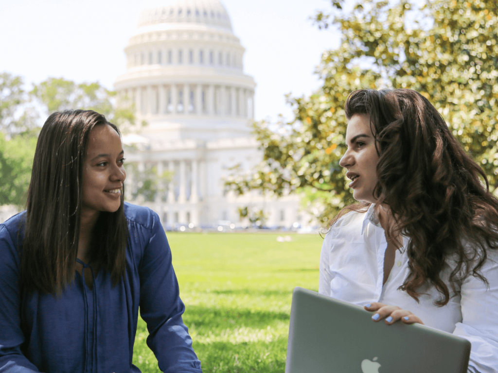 two students having a conversation in front of the Capitol Building