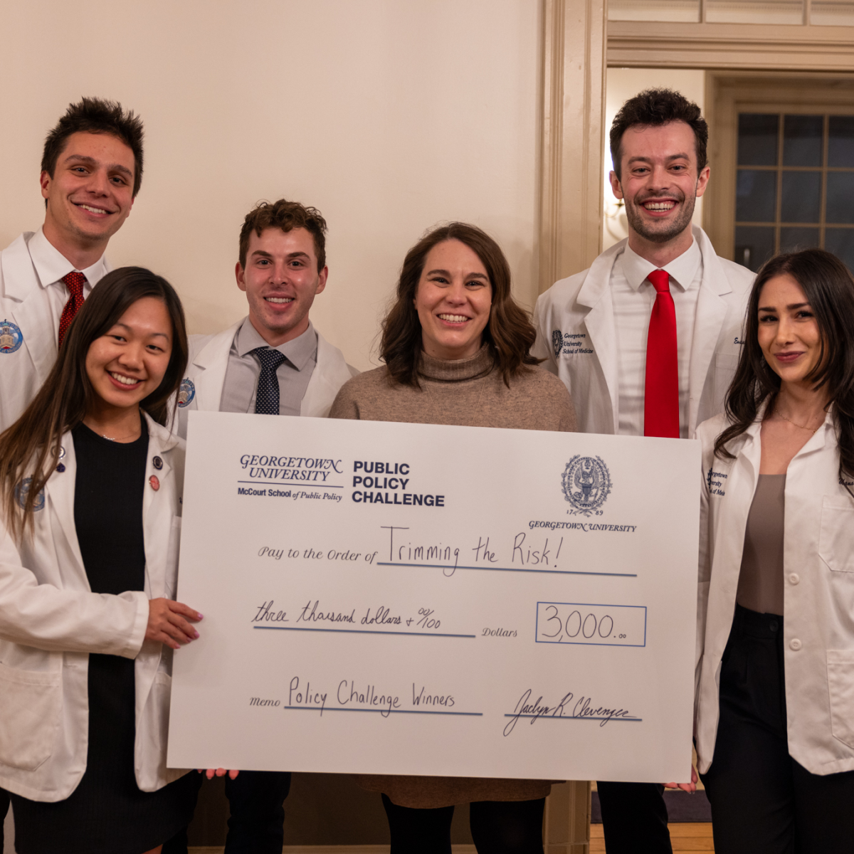 The School of Medicine team pose alongside Jacci Clevenger holding a commemorative check