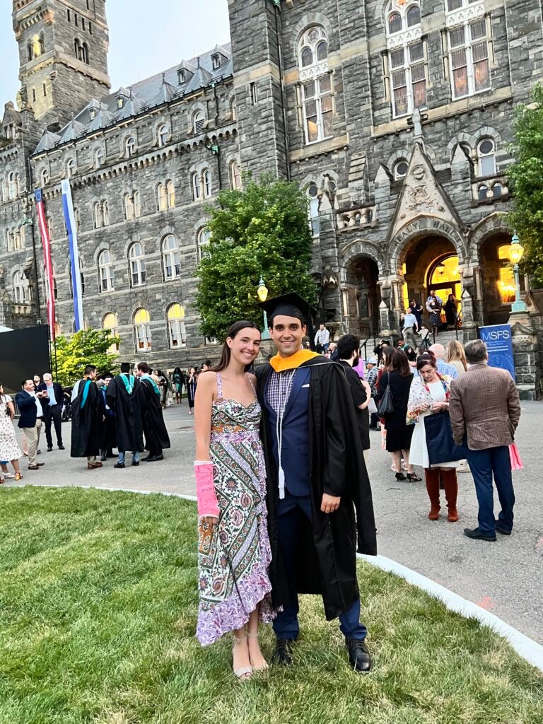 Lydia Sullivan and Ellis Obrien in front of Healy Hall after the 2023 McCourt School Commencement Ceremony.