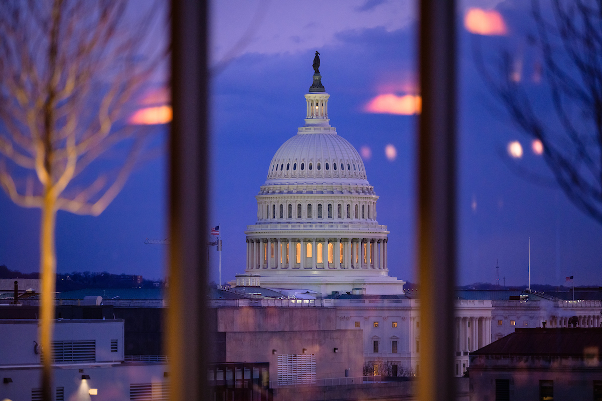 US Capitol seen from McCourt's 9th floor at sunset, sky is purple-blue with highlights of orange