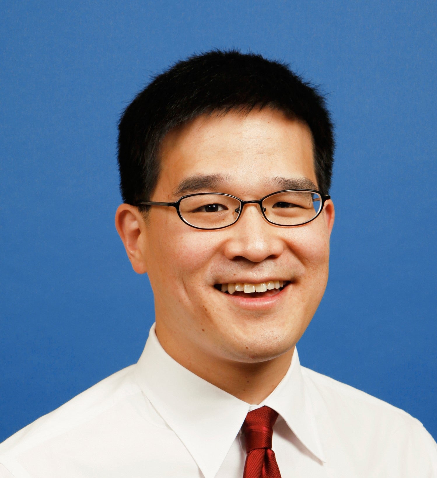 Headshot of Edwin Park against a blue background