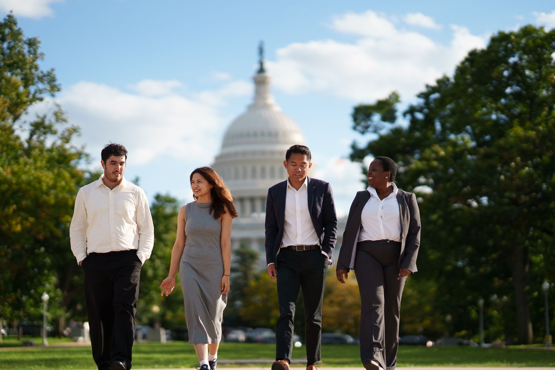 Four students walking together in front of the US Capitol building.