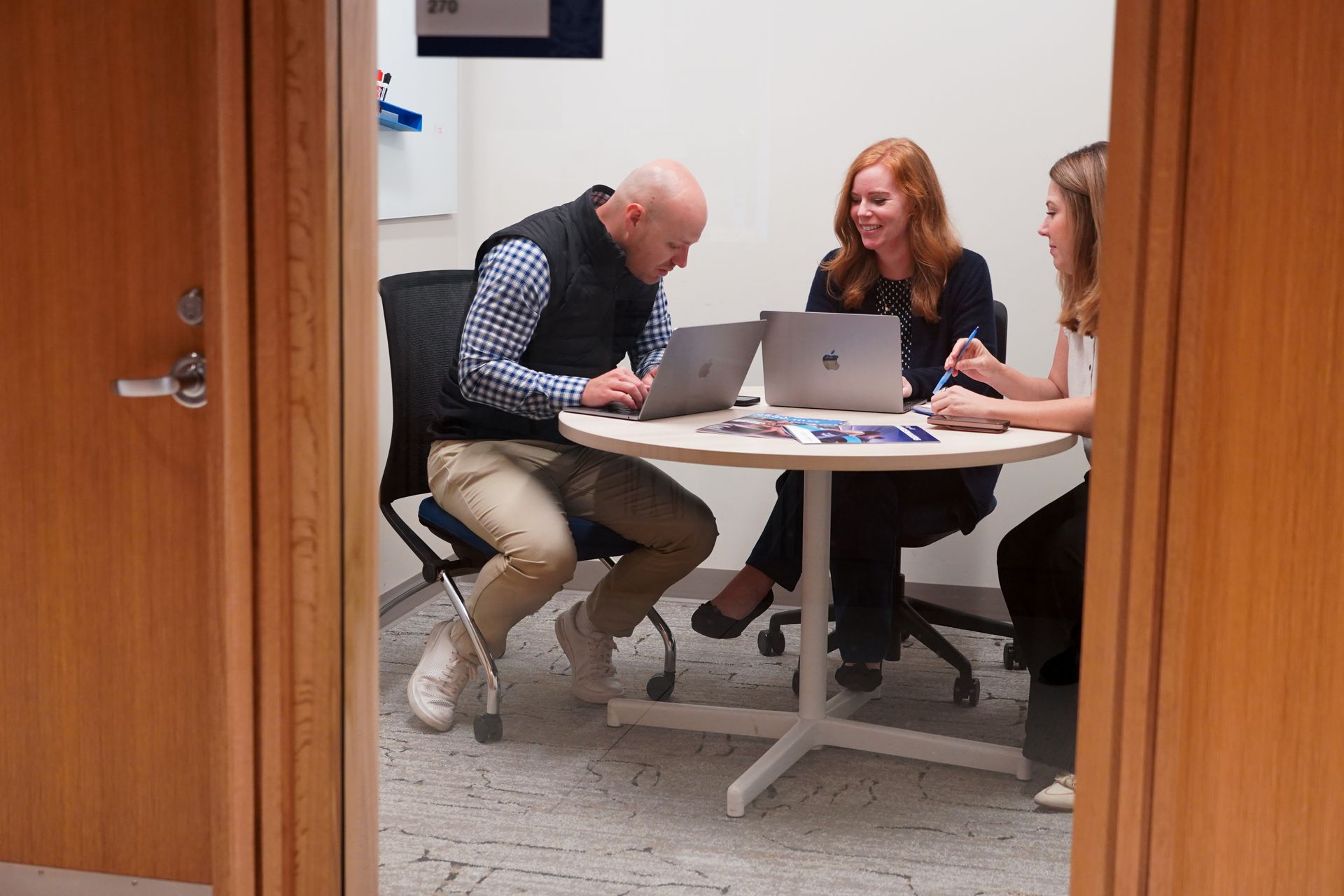 Three students studying together in a small breakout room.