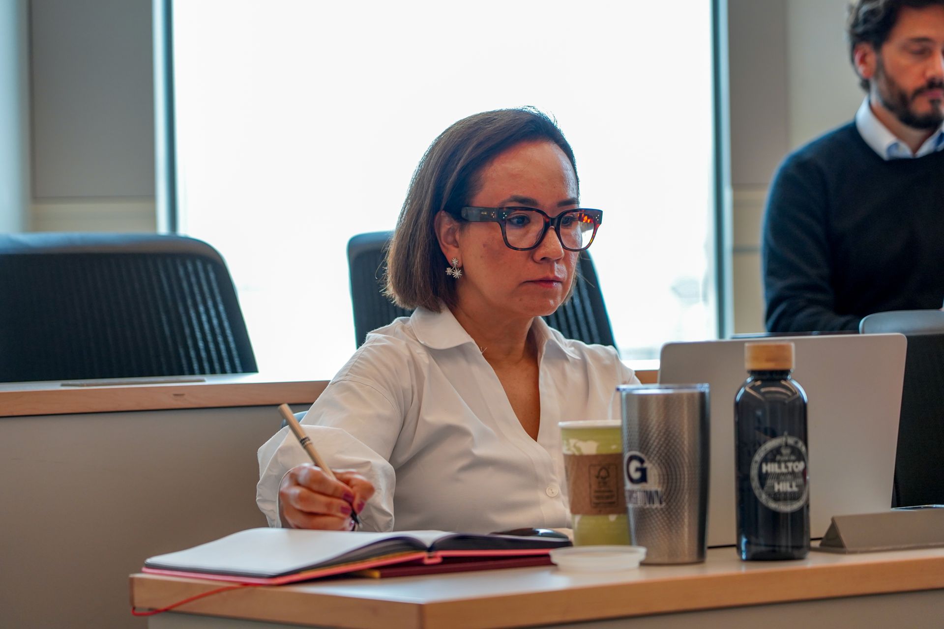 A student listens intently in class and takes notes.