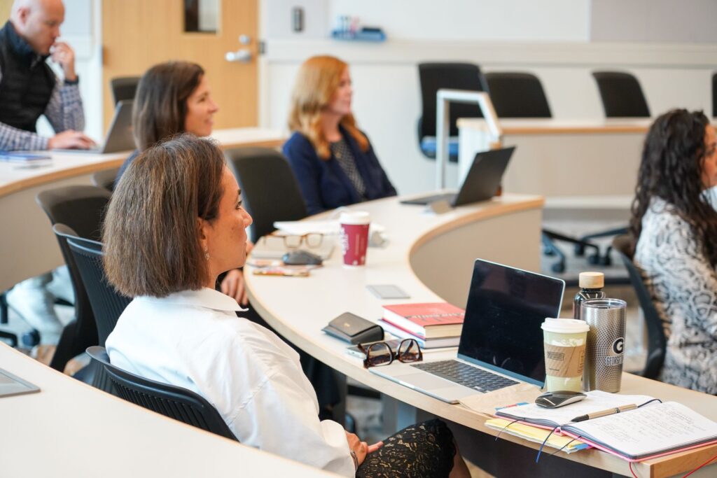 Five students in class, listening to a lecture.