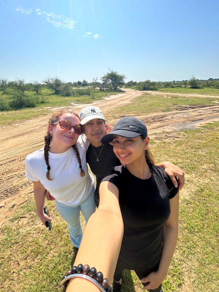 Three students together in a field.