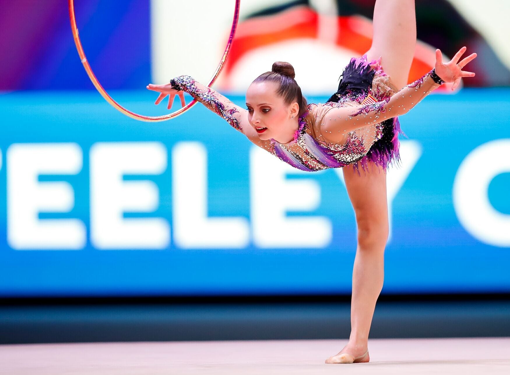 Woman performs rhythmic gymnastics routine with a hoop