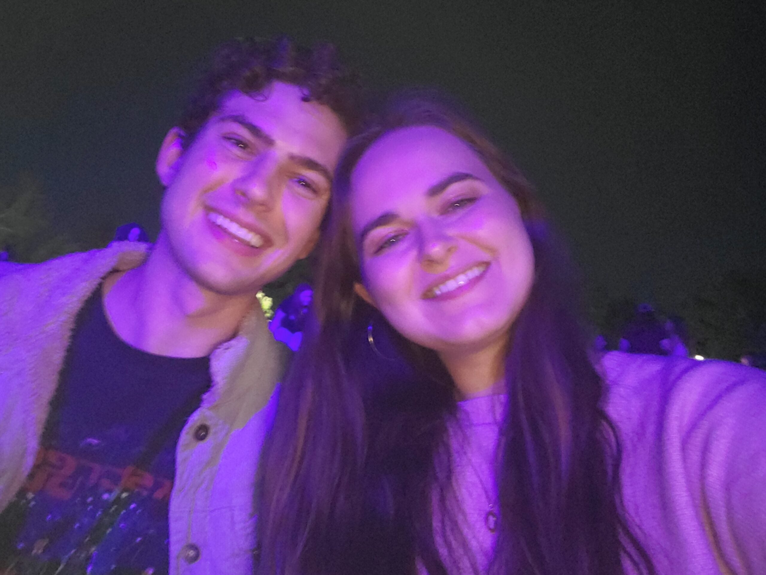 Selfie of a smiling couple taken in strong purple lighting