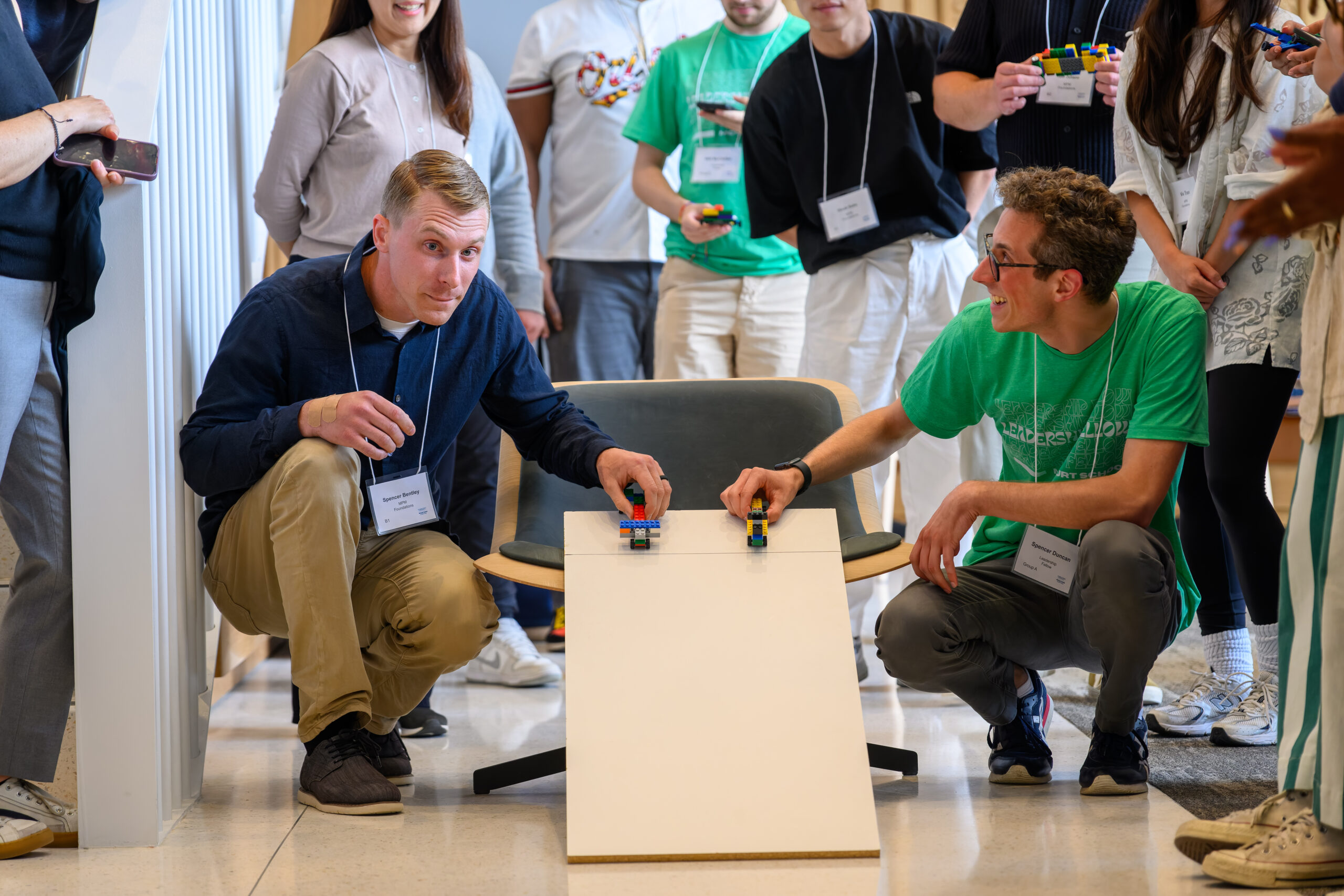Two men preparing to release lego boxcars down long slide
