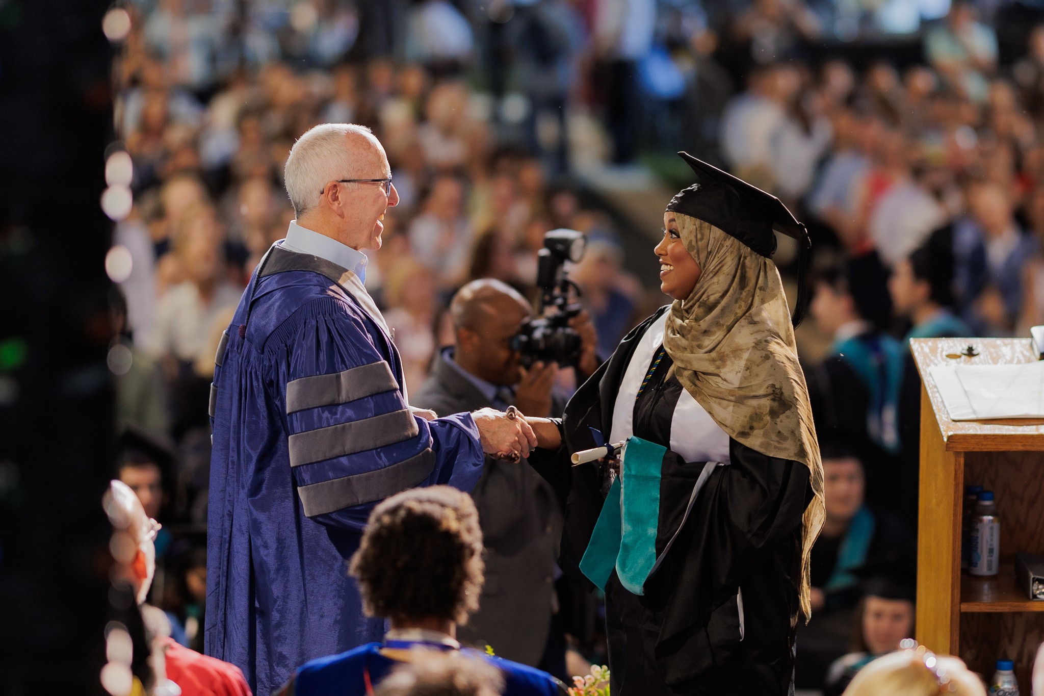 Frank McCourt shakes hand with graduating student during commencement