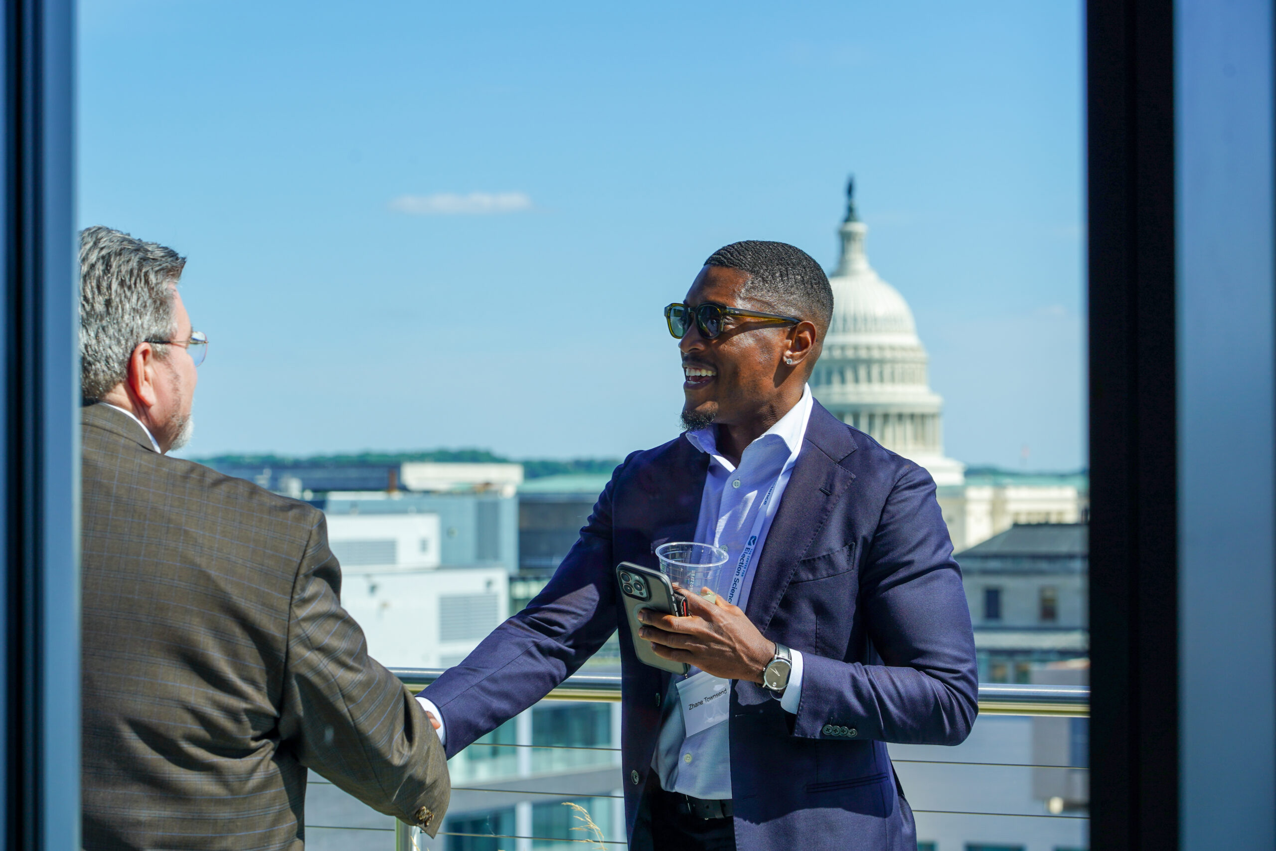 Two men shaking hands with US Capitol in the background