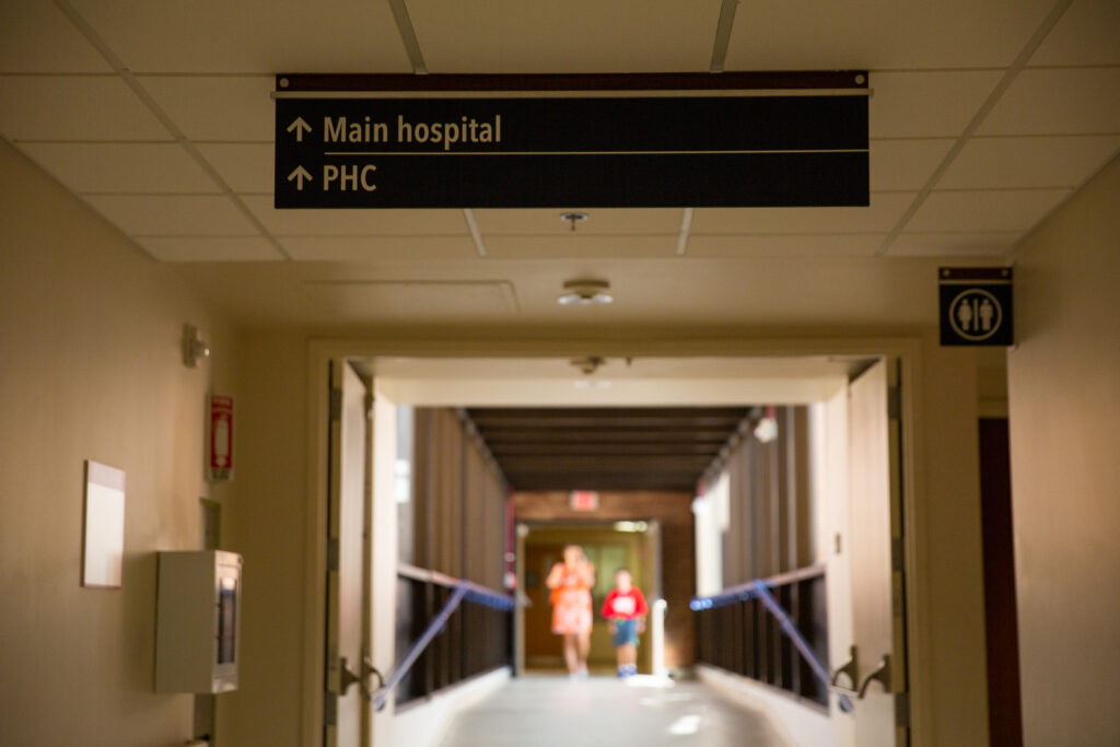 Empty hallway, sign reads "Hospital" with directional arrow