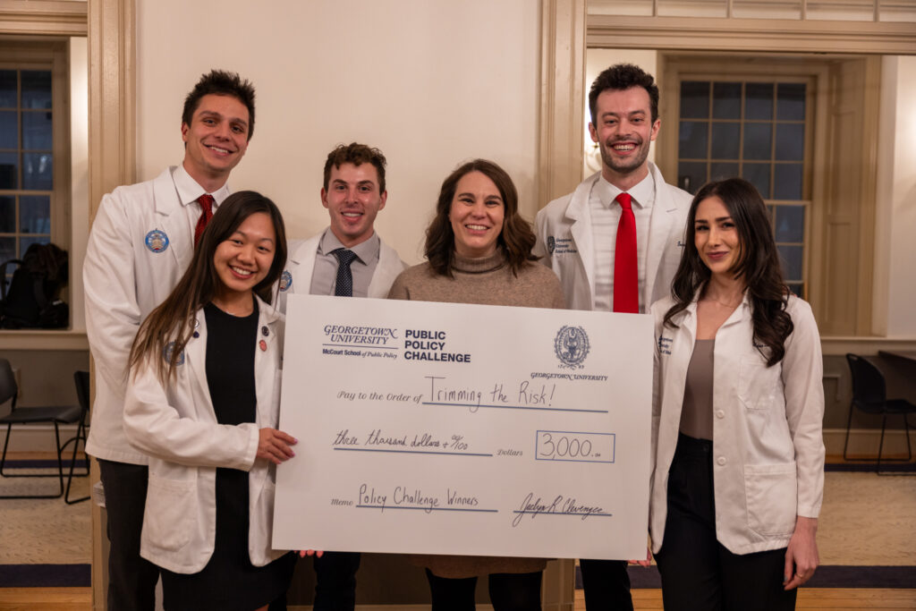 Six people holding up a giant cheque 