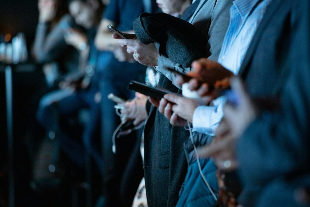 A line of illuminated phones held by people
