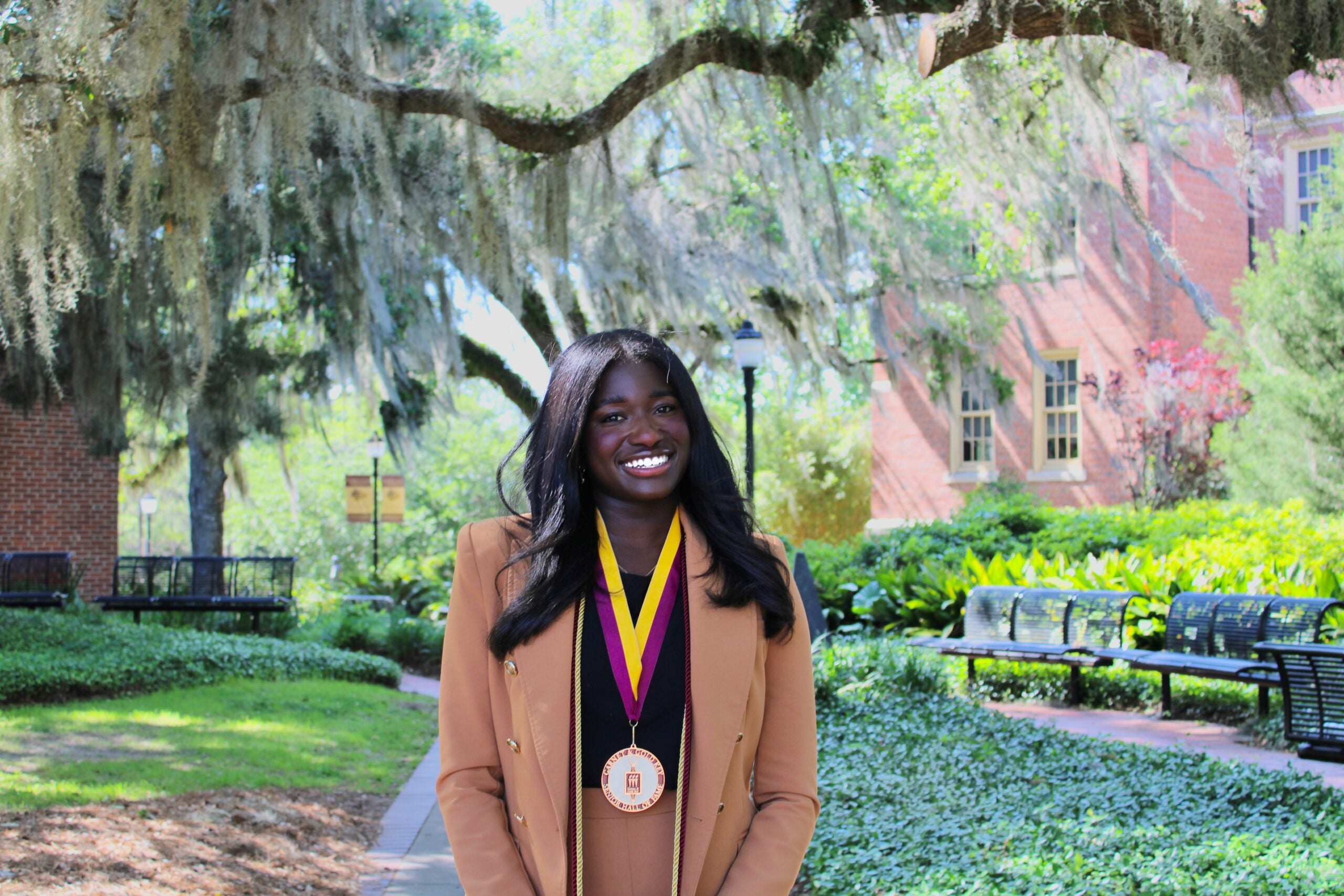 Abril Hunter stands under large tree canopy