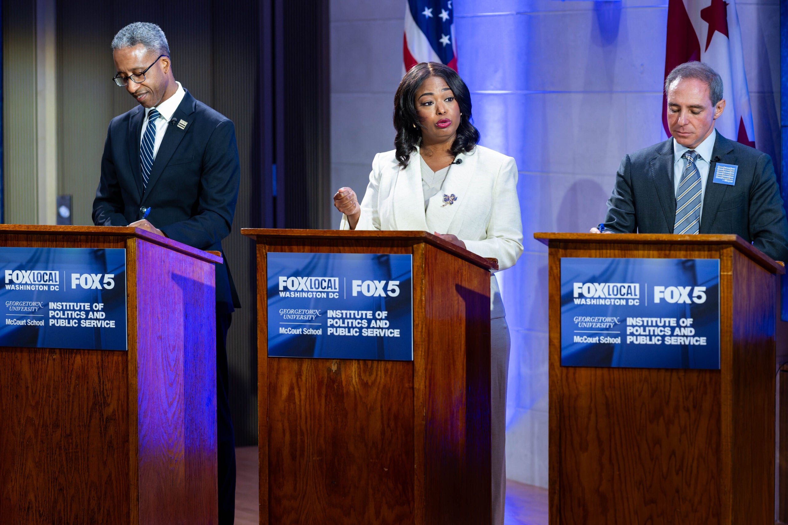 DC mayoral candidates stand behind lectern at McCourt School