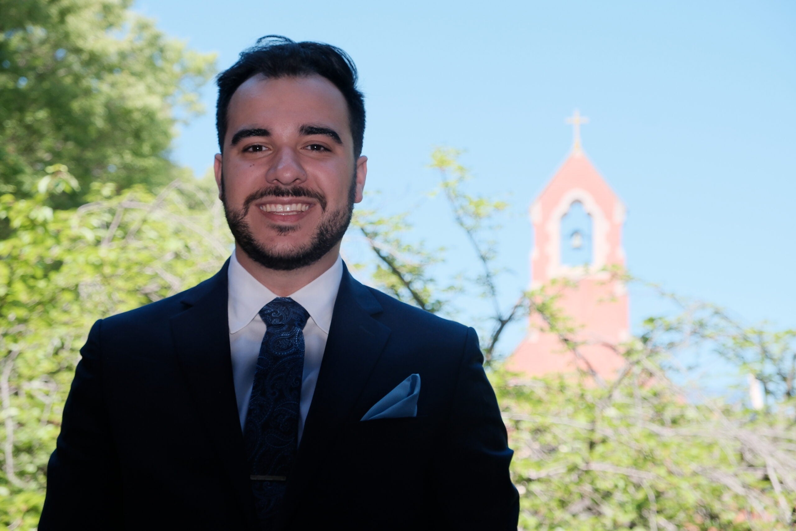 Santiago Vidal Cavlo in professional attire, standing in front of church