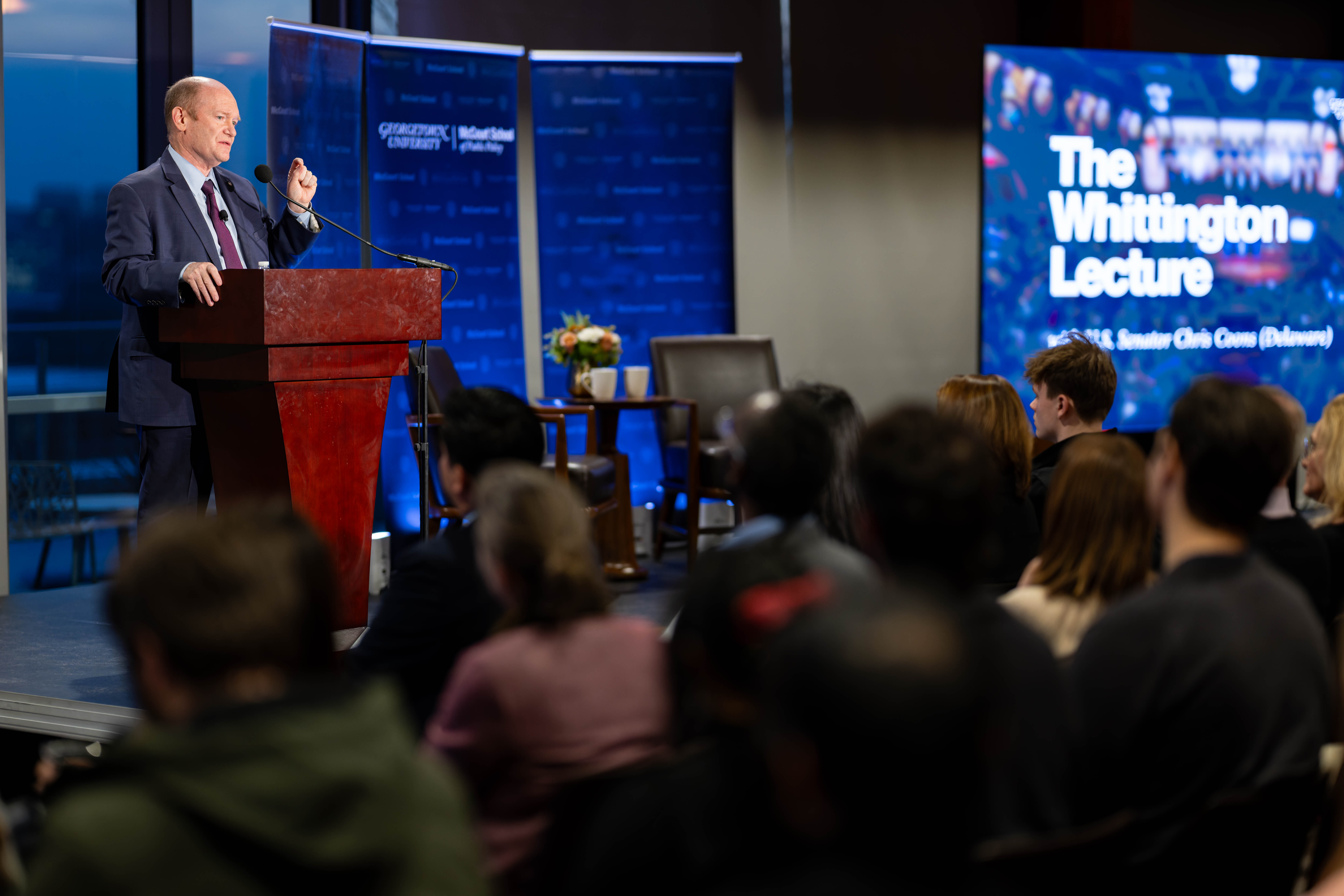Senator Coons at the lectern giving the 2025-2026 Whittington Lecture.