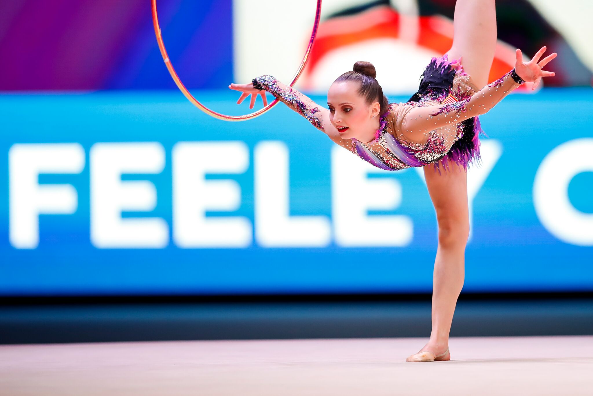 Woman performs rhythmic gymnastics routine with a hoop