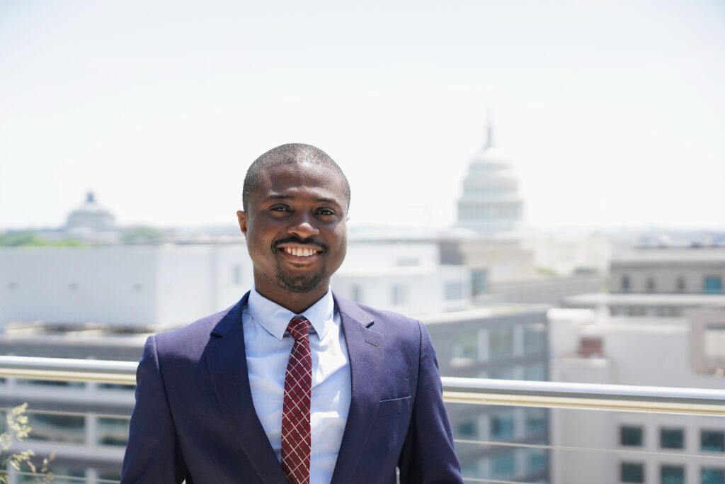 Nicholas Mensah on McCourt rooftop, US Capitol in background
