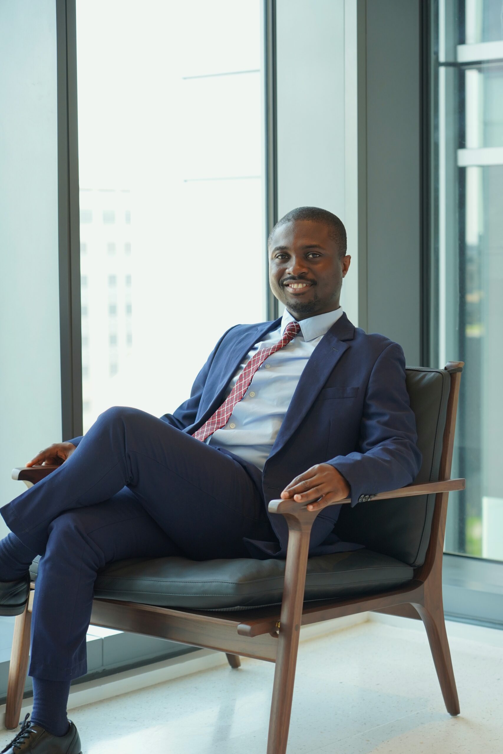 Nicholas Mensah sitting in navy blue suit