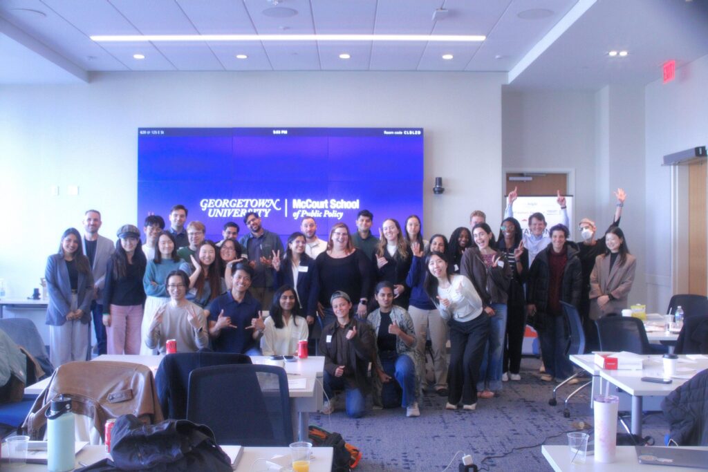 Large group of people posing in McCourt classroom