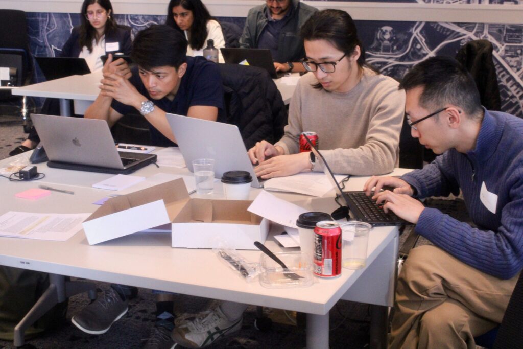Three people individually working on laptops
