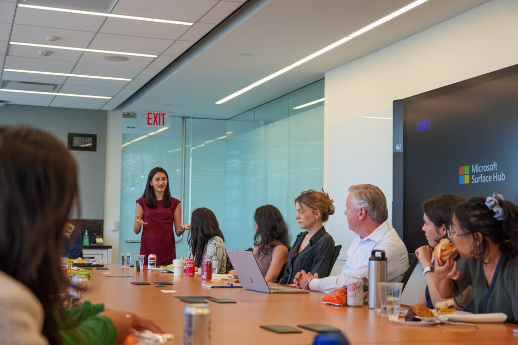 A woman leads presentation from the head of a very long table