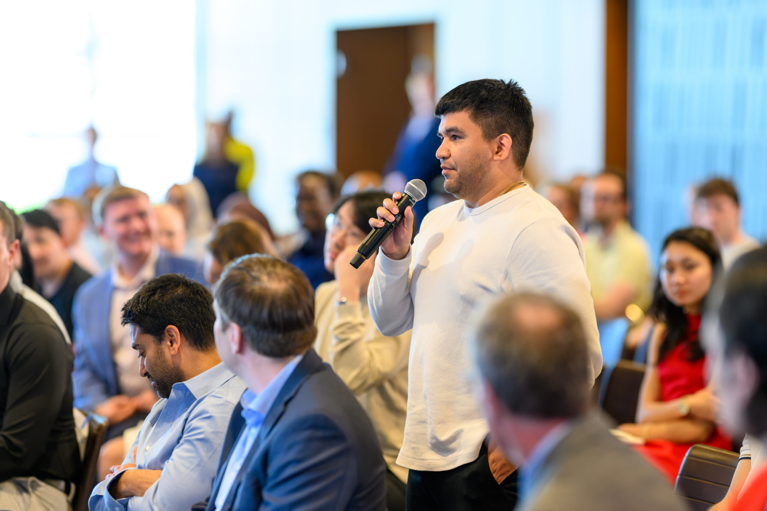 Young man speaking into microphone from audience
