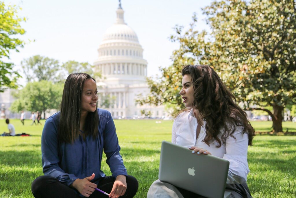 Two young women sitting on US Capitol lawn