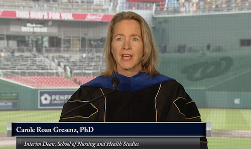 Dean Carole gives speech at National's Park  in regalia.