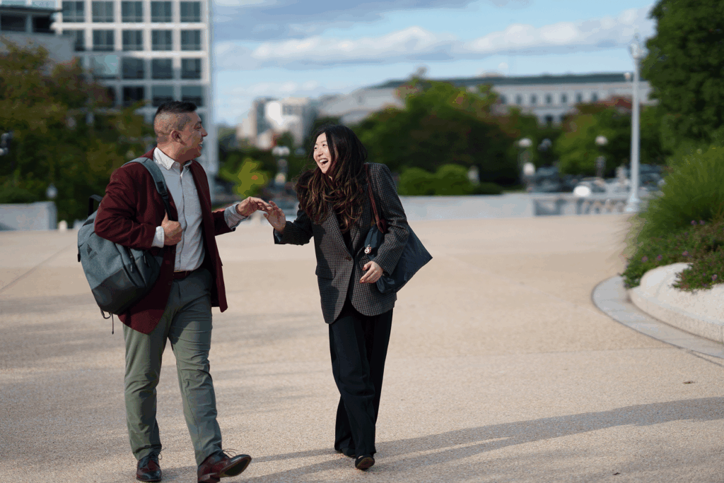 A man and a woman walking, talking, laughing outside