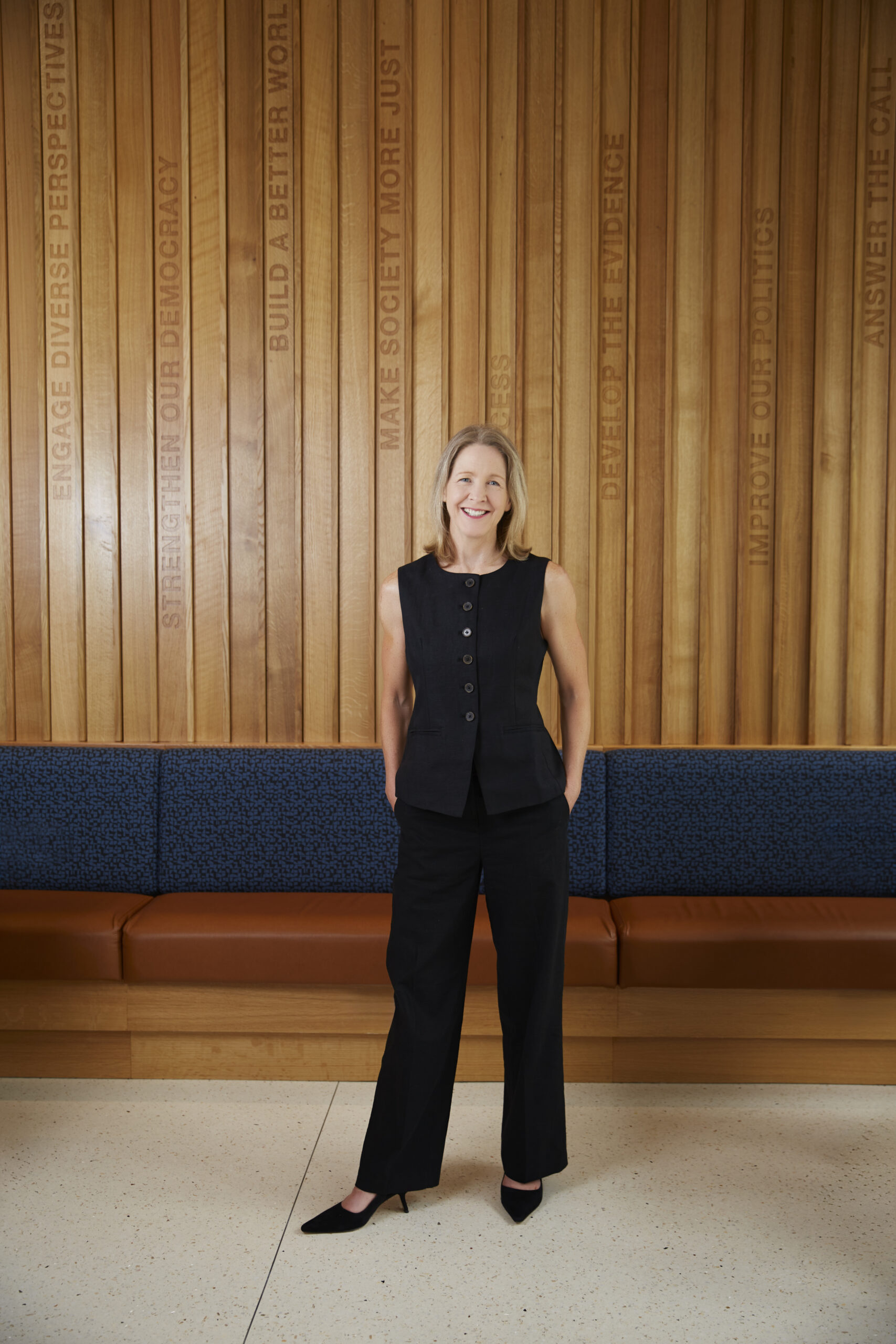 Dean Carole stands in McCourt lobby with hands in pocket