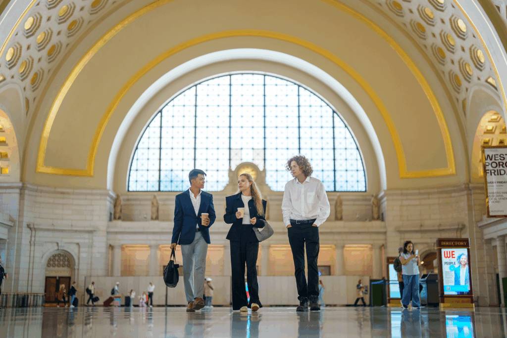 Three people walking in ornate building