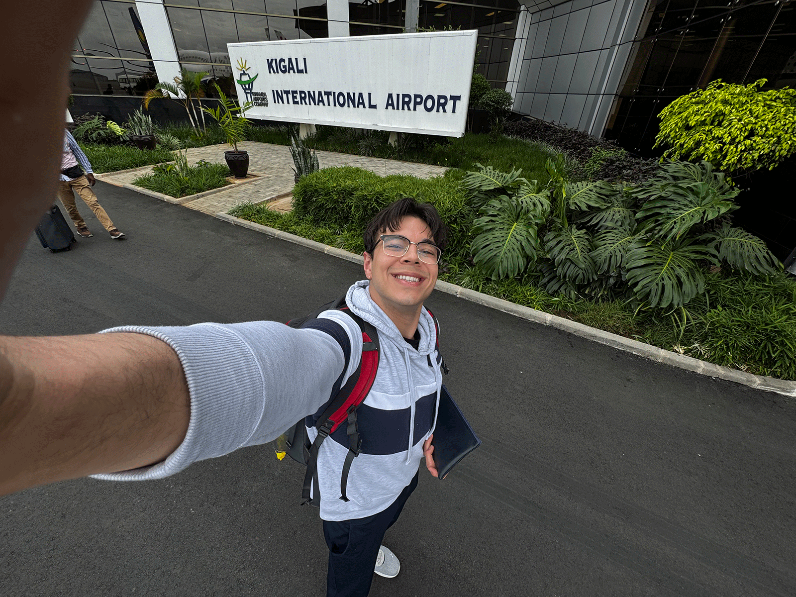 Gavin Ali Gondalwala takes selfie in front of Kigali International Airport, Rwanda