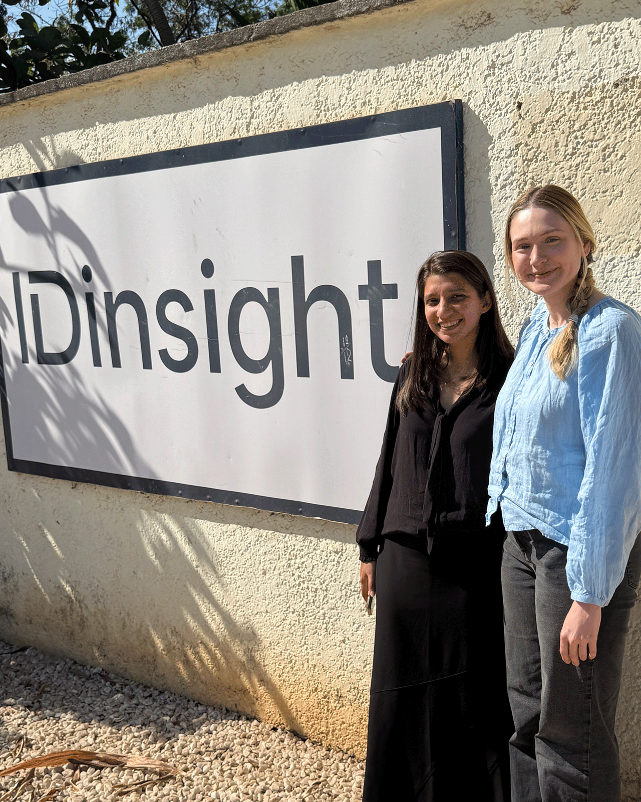 Lynzee Lee and colleague in front of IDinsight sign