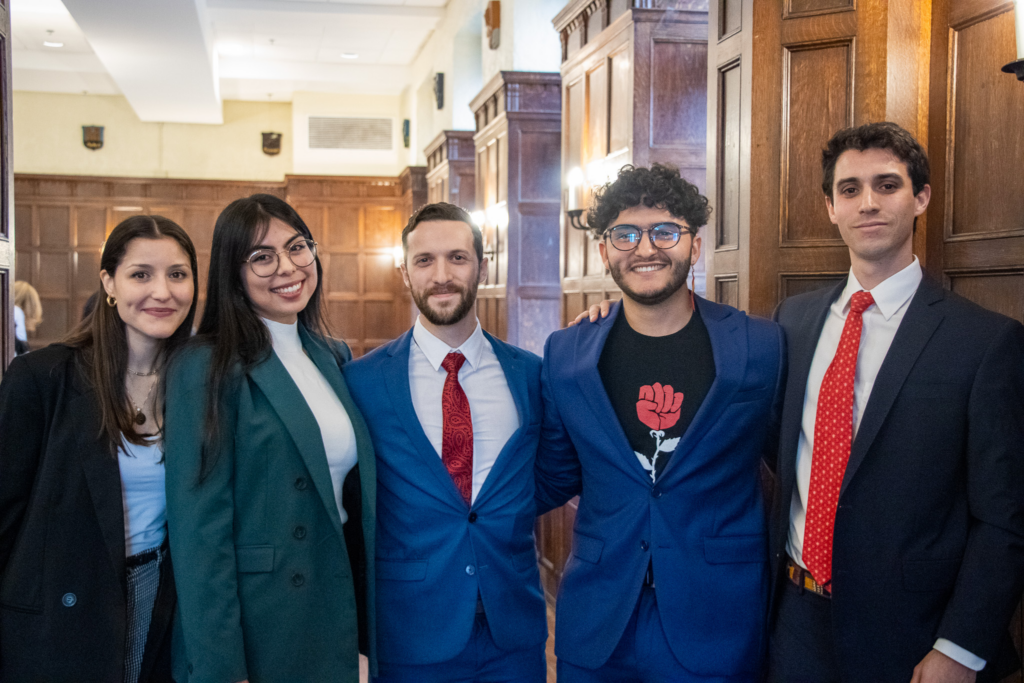 Five people standing side-by-side in business apparel