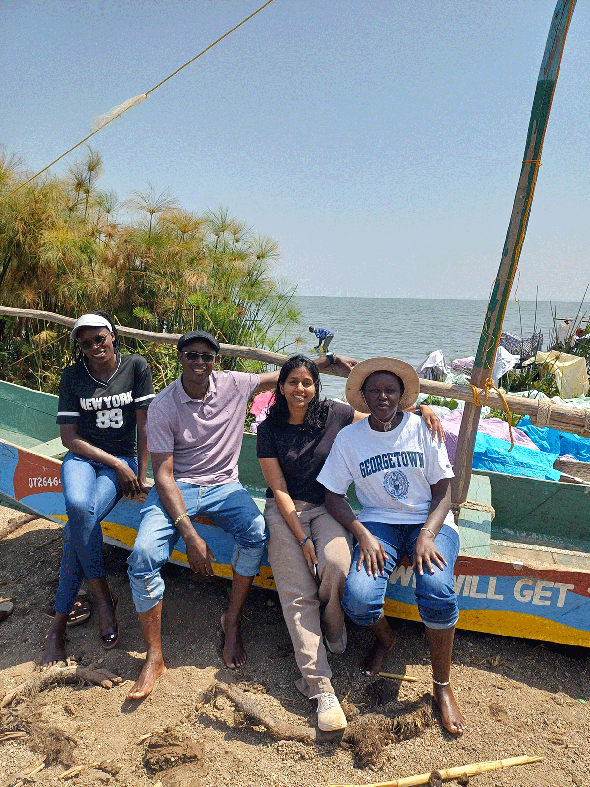 Suraj and colleagues sitting on wooden sail boat