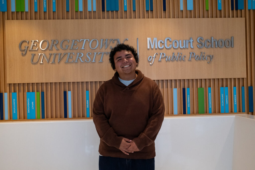 Martin Orea (JPPP'30) stands in front of McCourt School sign.