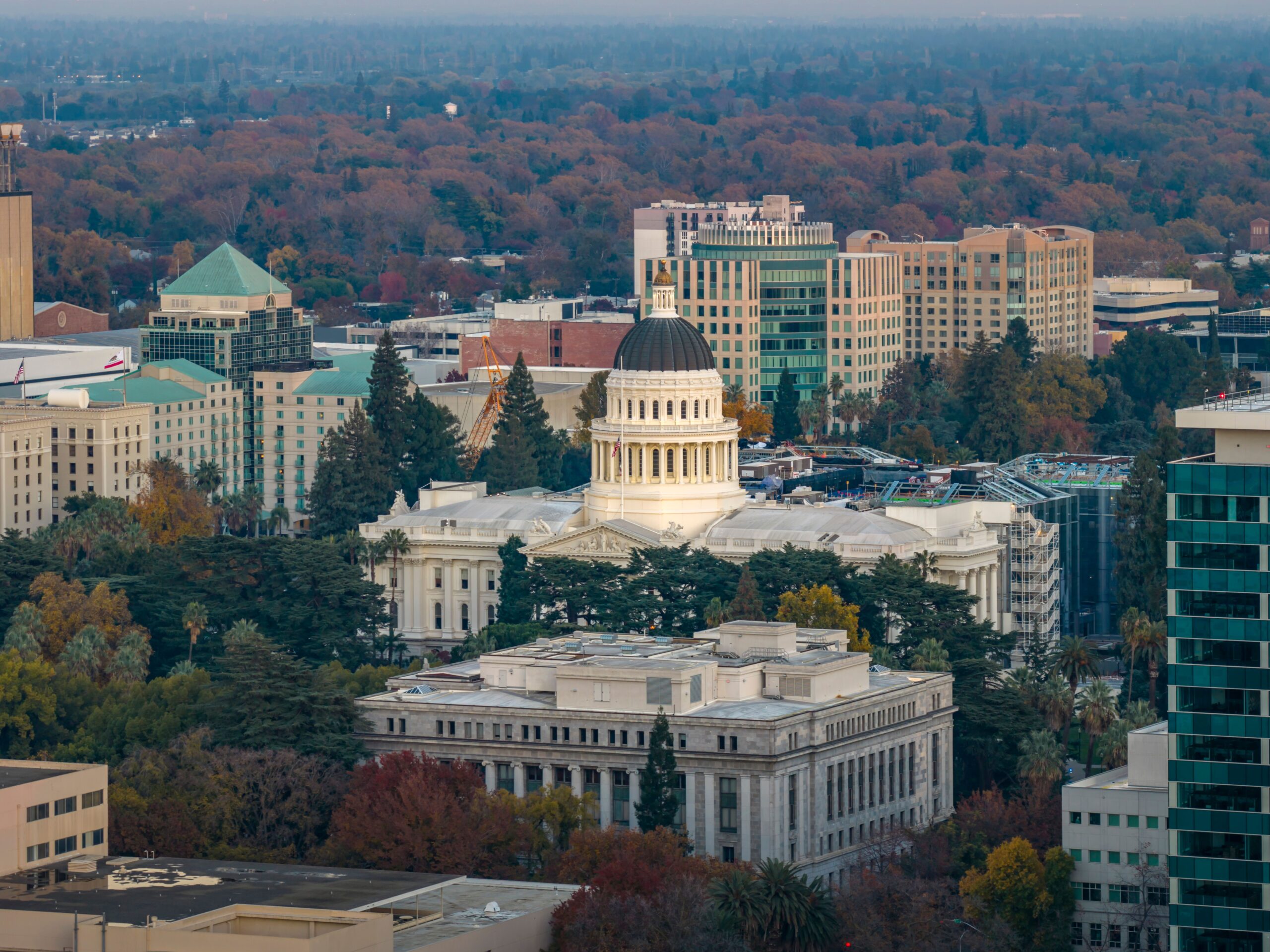 The outside of a state capitol building and statue.