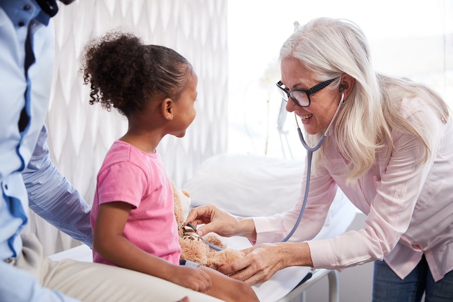 Doctor listens to child's heartbeat.